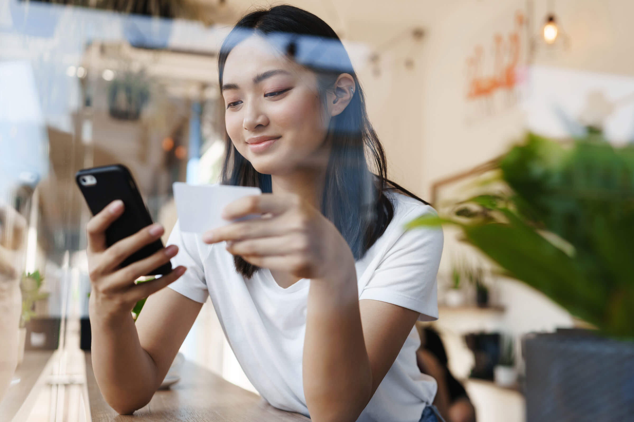 Asian woman making a a payment on her mobile phone.